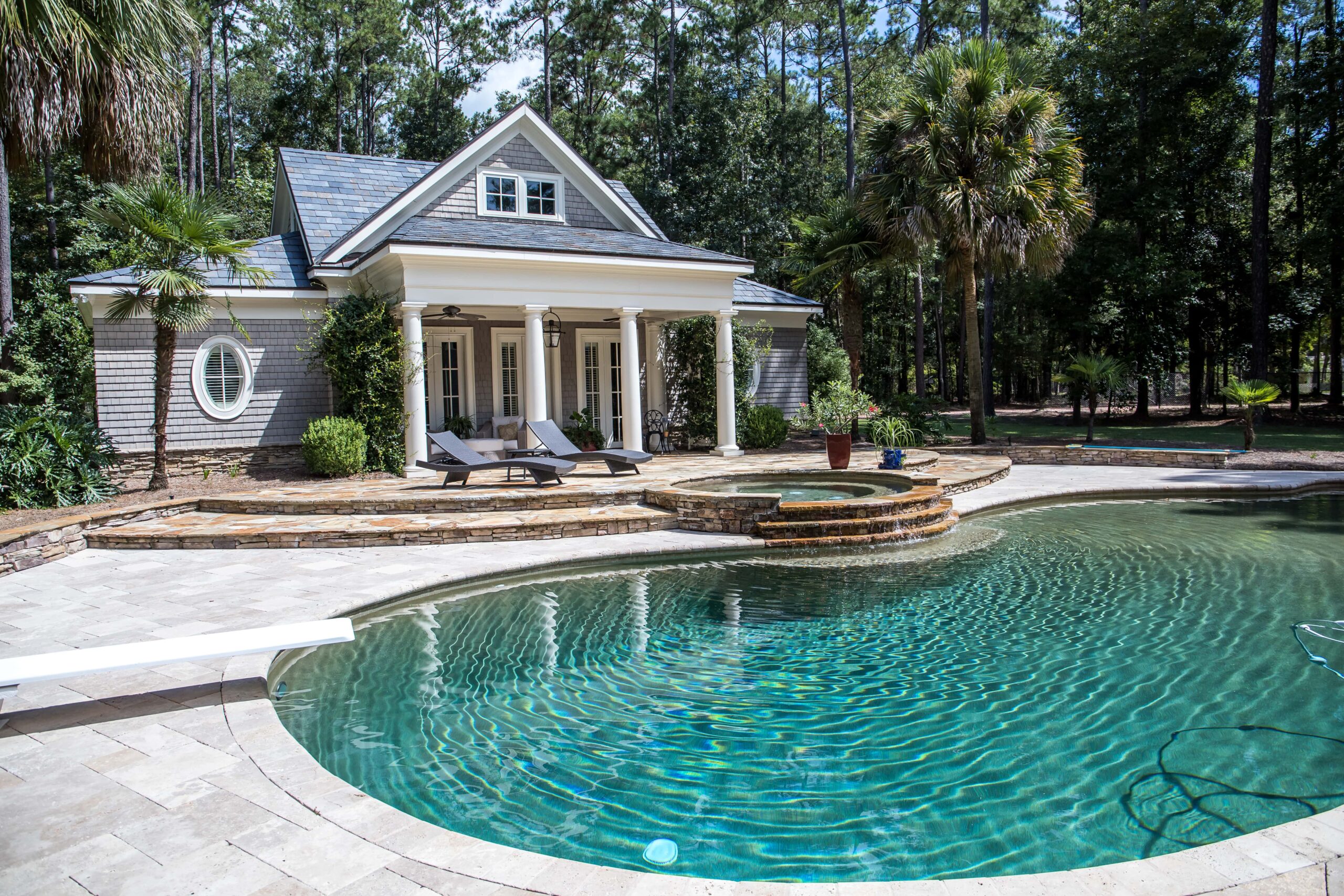 Luxury guest house by a pool with elegant landscaping and seating area