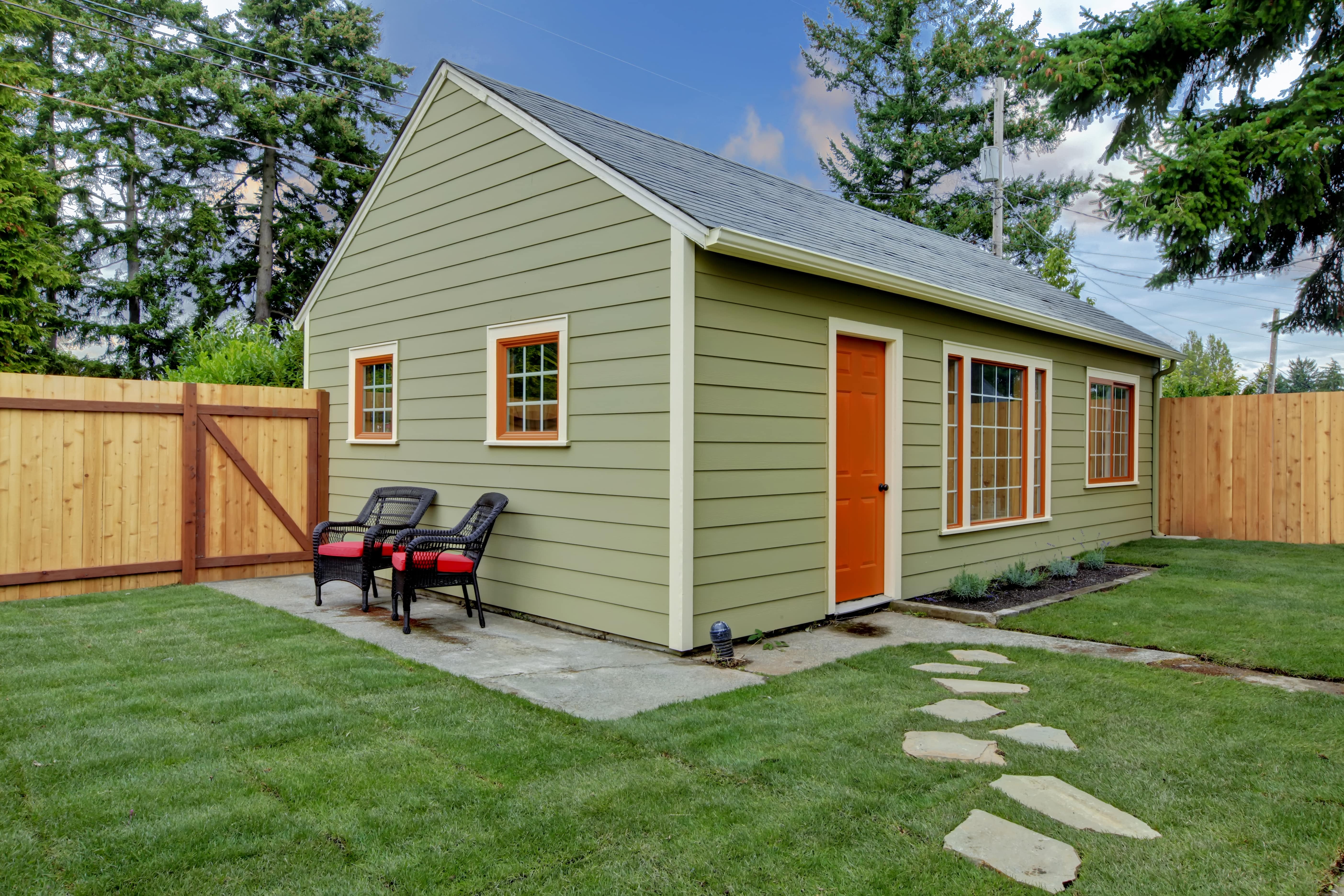 Backyard guest house with a small patio and modern fencing in a North Texas property