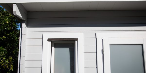 Close-up of a contemporary accessory dwelling unit (ADU) with white siding and sleek windows