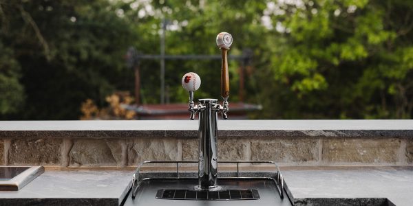 Outdoor kitchen beer tap setup in Celina, TX with baseball-themed handles