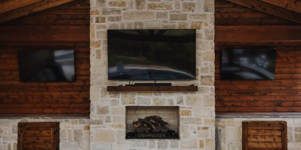 Outdoor living area with three wall-mounted TVs in Celina, TX